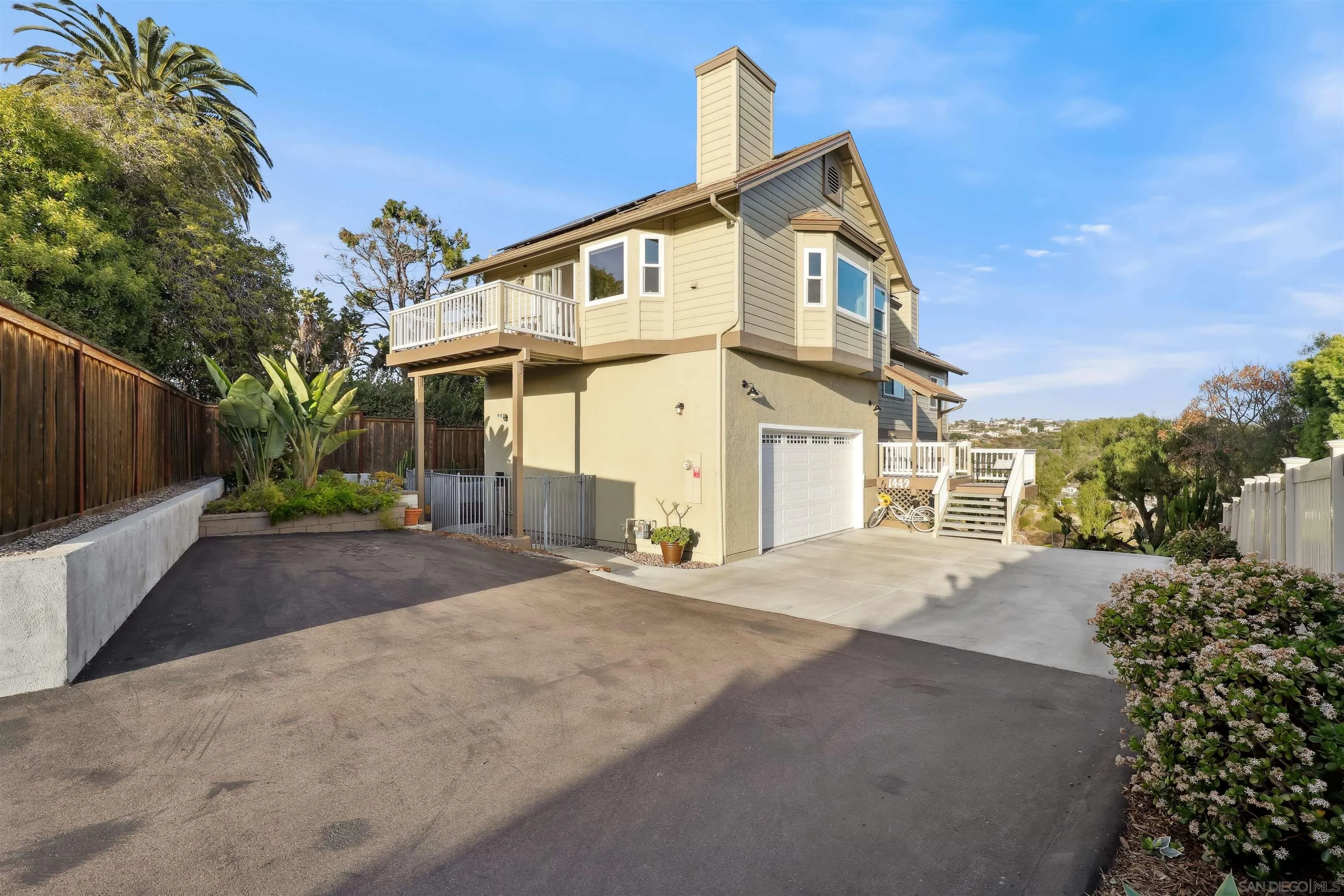 1449 Rainbow Ridge Lane Encinitas, CA 92024 - Photo 5 of 58 a view of a white house with a yard and plants