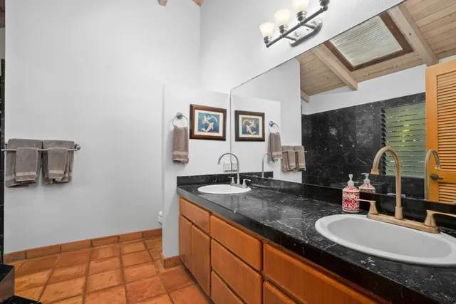 a bathroom with a granite countertop sink a mirror and shower