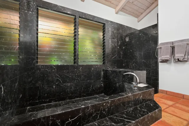 a en suite bathroom with a granite countertop sink and a mirror