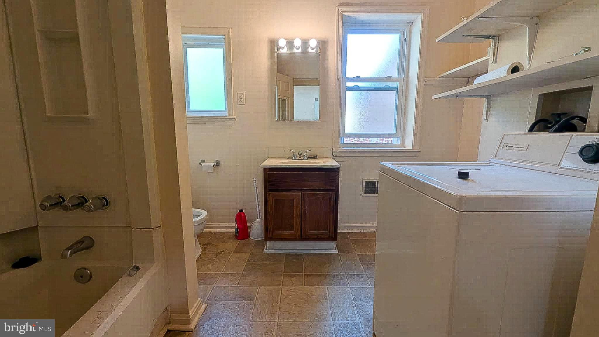 209 Penn Street Baltimore, MD 21201 - Photo 12 of 22 a bathroom with a bathtub sink and mirror
