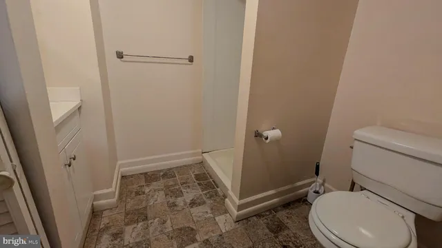 a white toilet sitting next to a shower