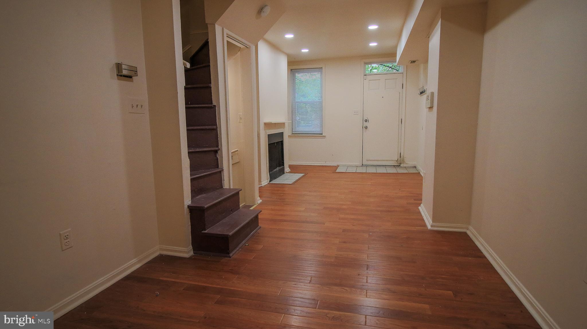 209 Penn Street Baltimore, MD 21201 - Photo 3 of 22 a view of a hallway with wooden floor and a bathroom