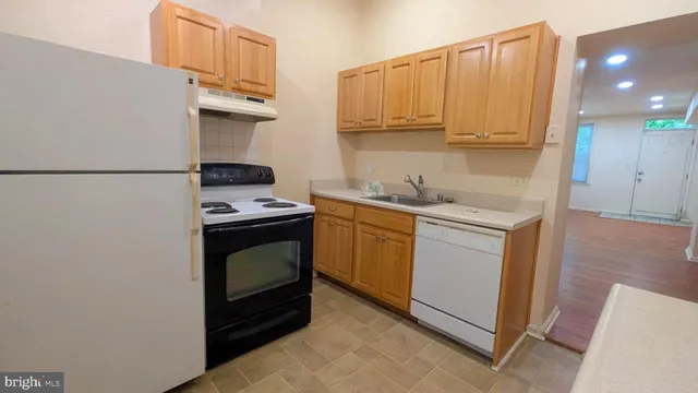 a kitchen with stainless steel appliances granite countertop a sink a stove a refrigerator a washer and dryer
