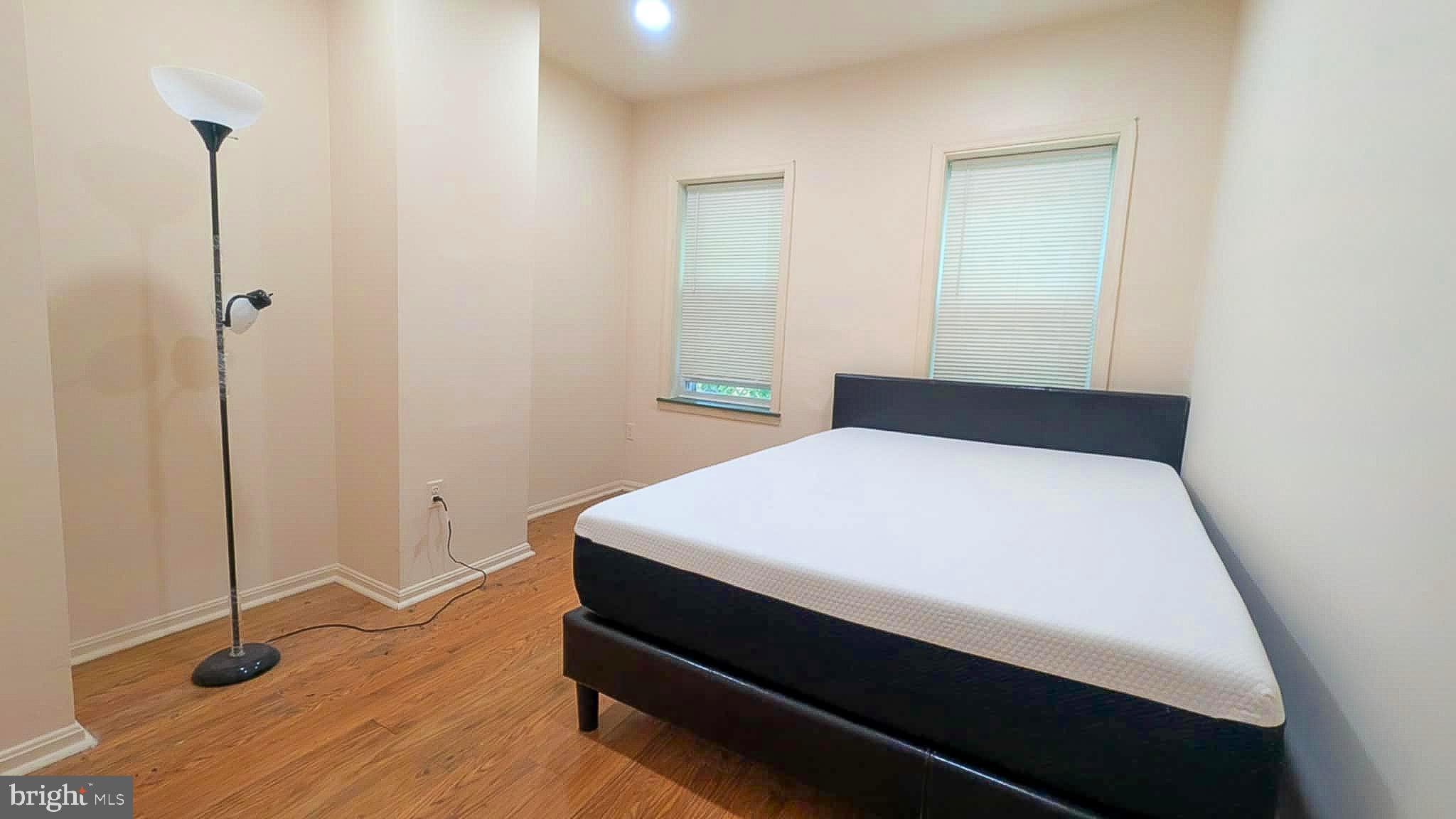 209 Penn Street Baltimore, MD 21201 - Photo 8 of 22 a bed sitting in a bedroom next to a window