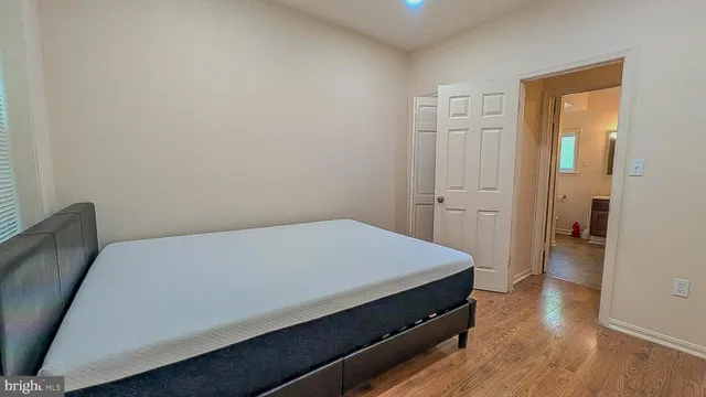 a room with a bed and wooden floor