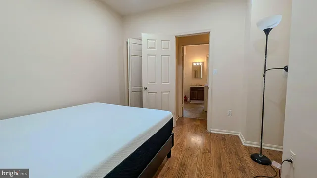 a bedroom with a bed and wooden floor