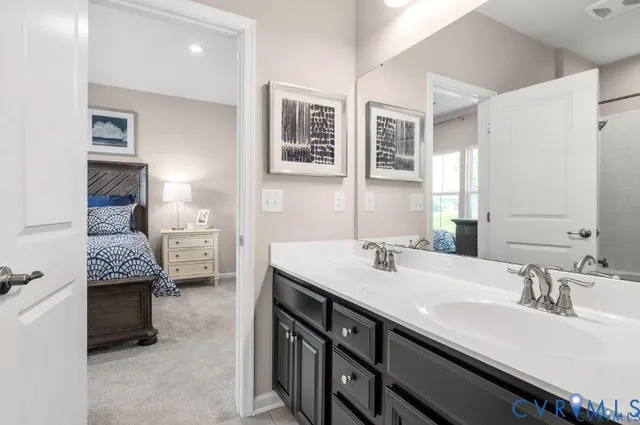 a en suite bathroom with a double vanity sink a mirror and a shower
