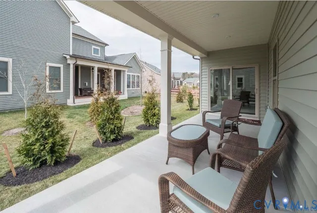 a view of a patio with table and chairs potted plants and floor to ceiling window