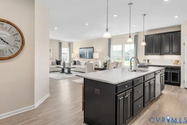 a kitchen with stainless steel appliances granite countertop a sink stove and wooden floor