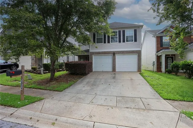 a front view of a house with a yard and a garage