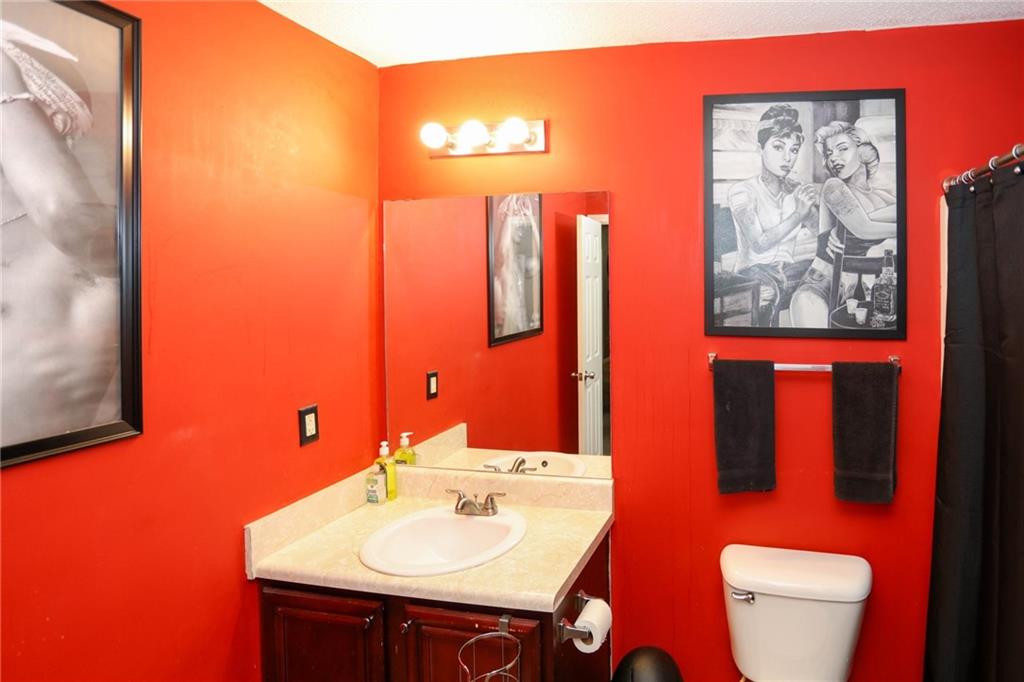 5854 El Segundo Way Atlanta, GA 30349 - Photo 21 of 63 a bathroom with a sink mirror and toilet