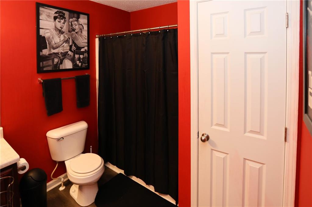 5854 El Segundo Way Atlanta, GA 30349 - Photo 23 of 63 a white toilet sitting next to a shower curtain