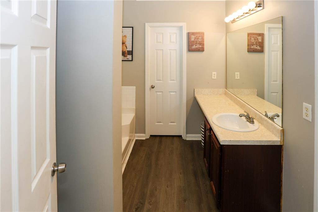 5854 El Segundo Way Atlanta, GA 30349 - Photo 29 of 63 a bathroom with a sink a mirror and a shower