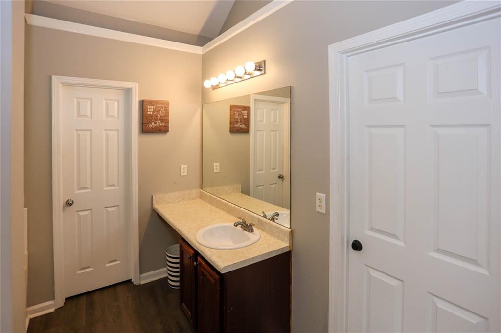 5854 El Segundo Way Atlanta, GA 30349 - Photo 30 of 63 a bathroom with a sink a mirror and a shower