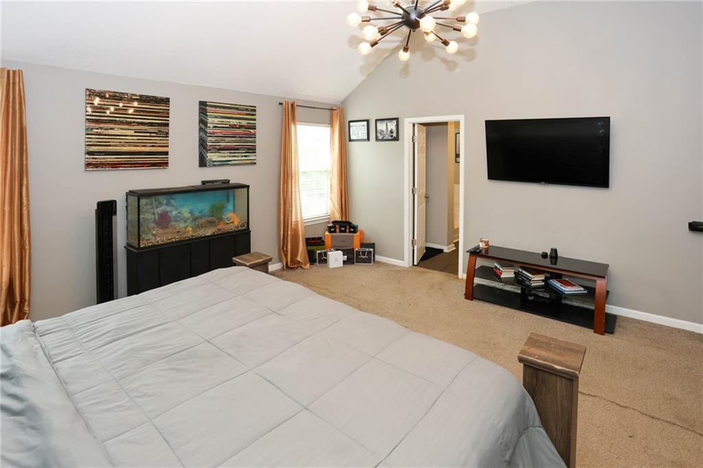 5854 El Segundo Way Atlanta, GA 30349 - Photo 34 of 63 a bedroom with a bed a mirror and a flat tv screen on dresser