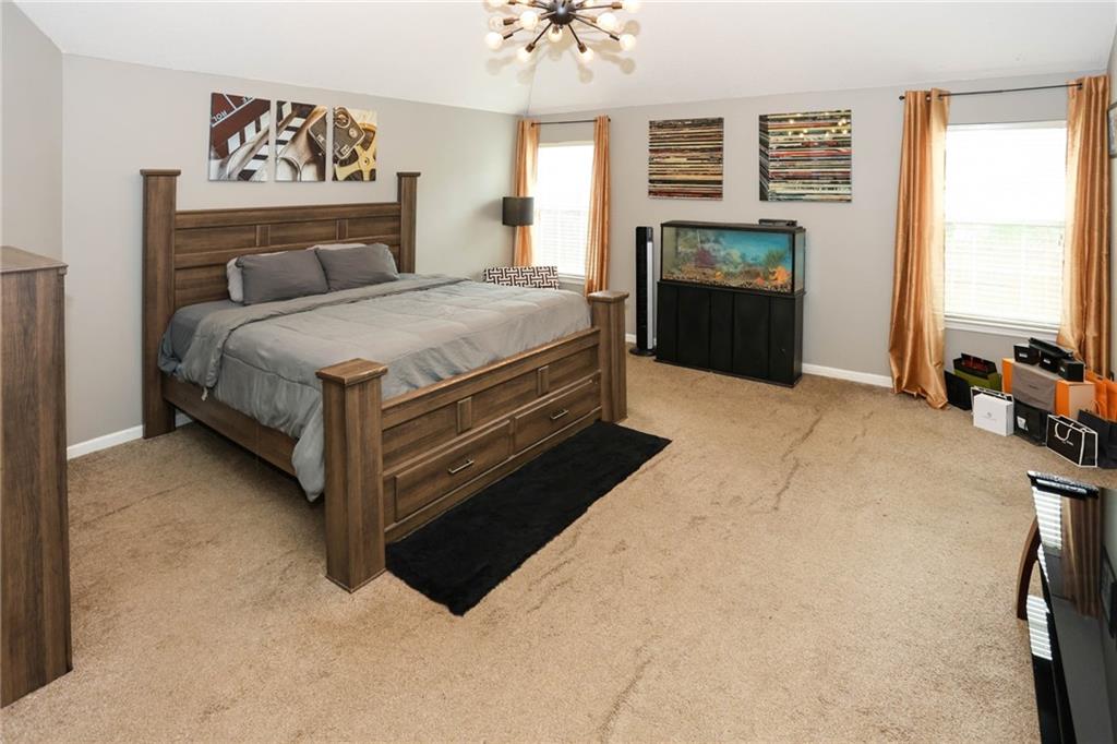 5854 El Segundo Way Atlanta, GA 30349 - Photo 35 of 63 a bedroom with a bed and a chandelier