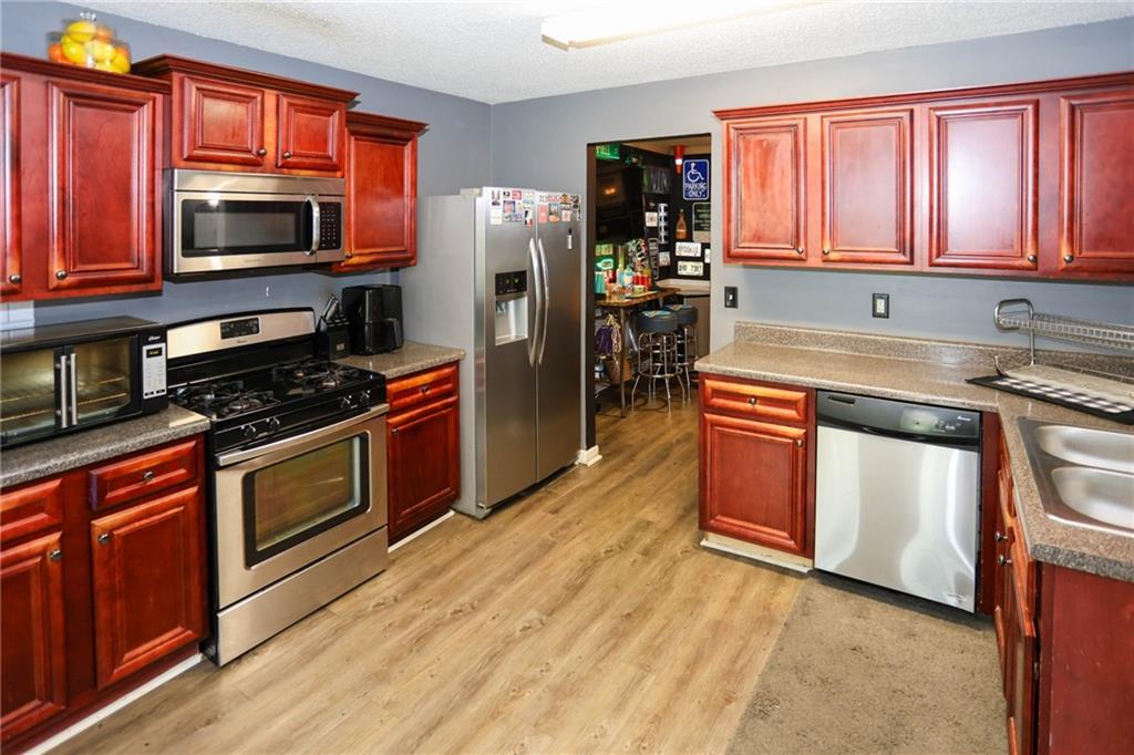 5854 El Segundo Way Atlanta, GA 30349 - Photo 5 of 63 a kitchen with stainless steel appliances granite countertop a stove a sink dishwasher a microwave oven with granite countertops and cabinets
