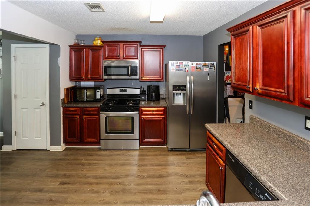 5854 El Segundo Way Atlanta, GA 30349 - Photo 6 of 63 a kitchen with stainless steel appliances granite countertop a refrigerator stove and oven