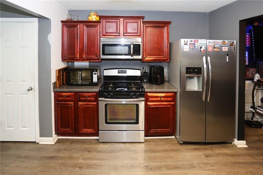 5854 El Segundo Way Atlanta, GA 30349 - Photo 7 of 63 a kitchen with granite countertop a refrigerator stove and microwave