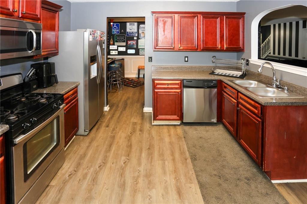 5854 El Segundo Way Atlanta, GA 30349 - Photo 10 of 63 a kitchen with stainless steel appliances granite countertop a stove a sink dishwasher and a refrigerator