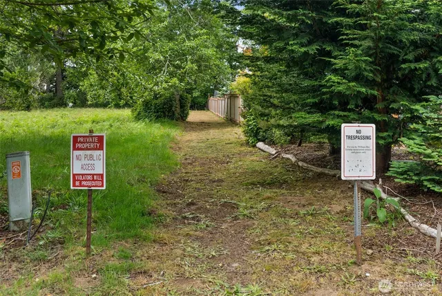 a sign that is sitting in front of a big yard