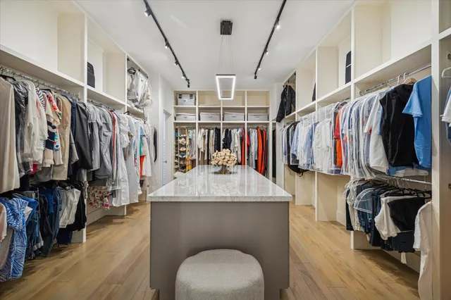 a view of walk in closet with clothes and shoes
