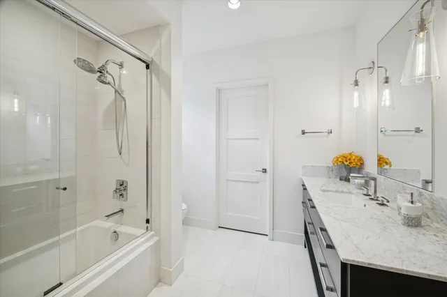 a bathroom with a granite countertop sink a mirror and a bathtub