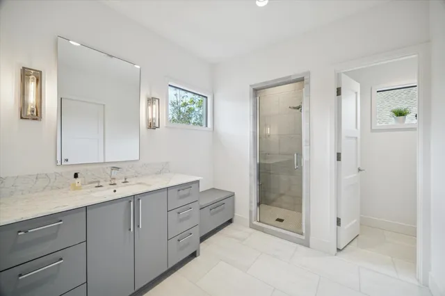 a spacious bathroom with double sink shower and mirror