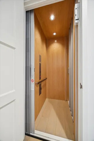a view of a hallway with a glass door and furniture