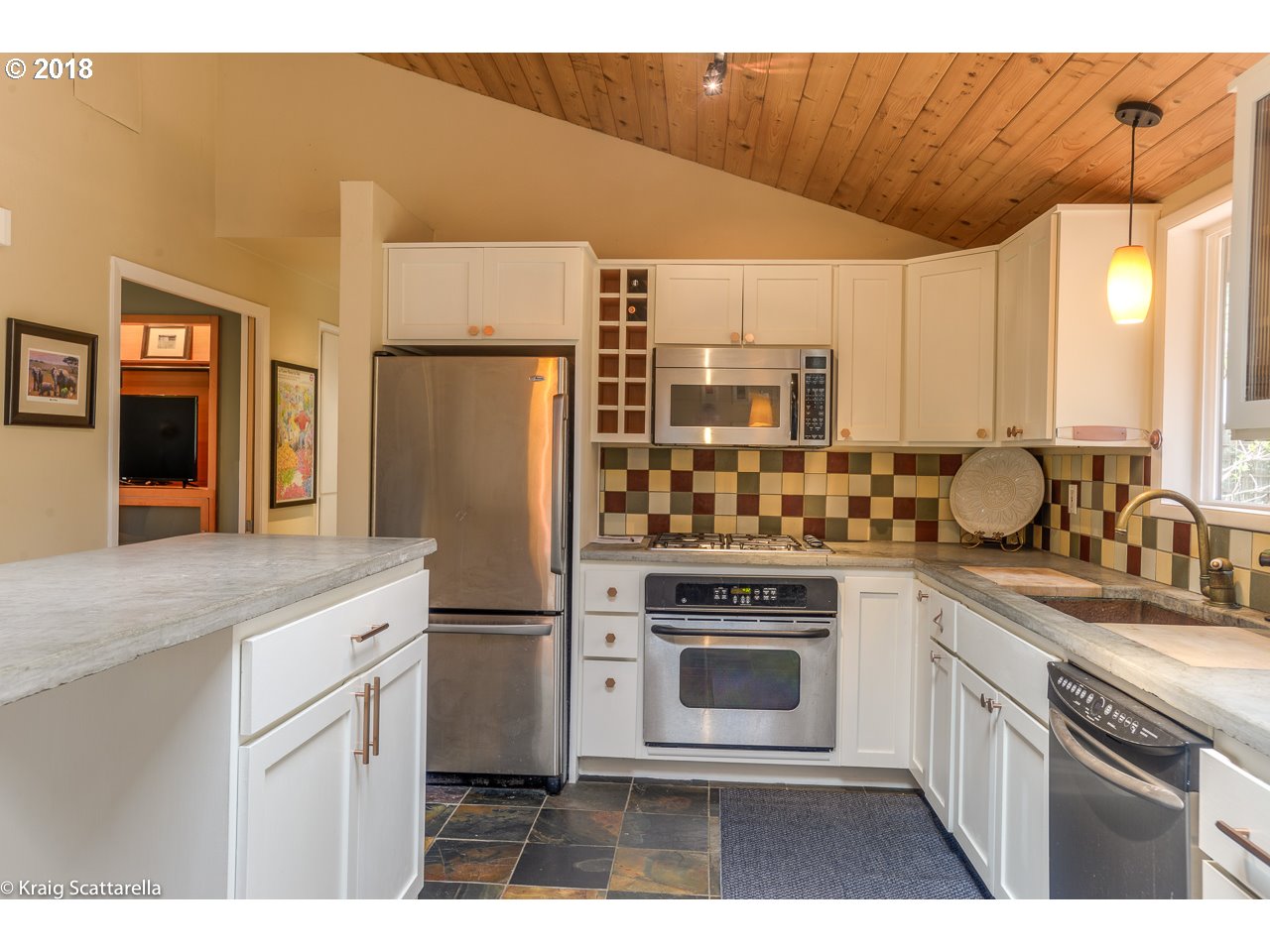 9 Southwest Collins Street Portland, OR 97219 - Photo 9 of 26 a kitchen with stainless steel appliances a sink cabinets and a refrigerator