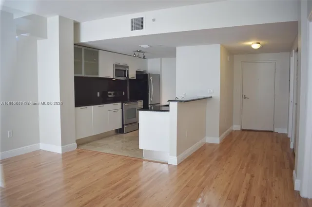 a view of a kitchen with a sink and a refrigerator