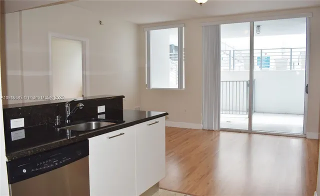 a kitchen with granite countertop a stove a sink and wooden floor