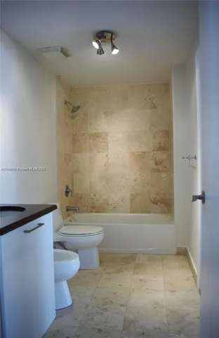 a bathroom with a toilet a sink and bathtub
