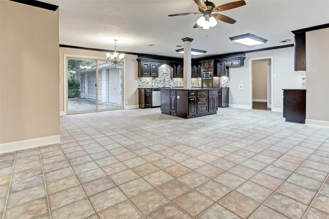a large white kitchen with a sink and chandelier