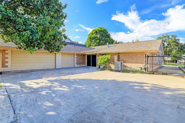 a view of a house with a yard and large tree