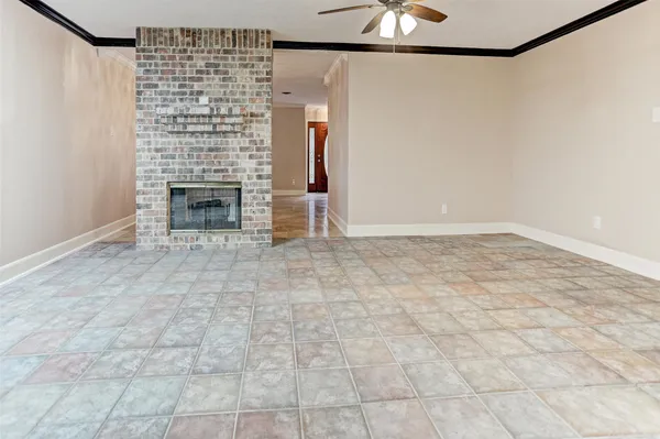 a view of empty room with fireplace and wooden floor