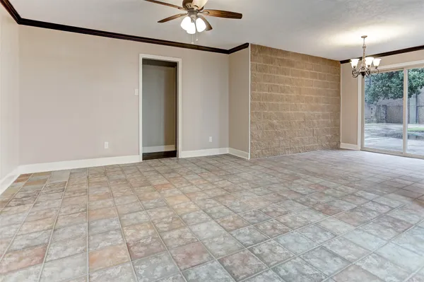 a view of an empty room with a chandelier fan