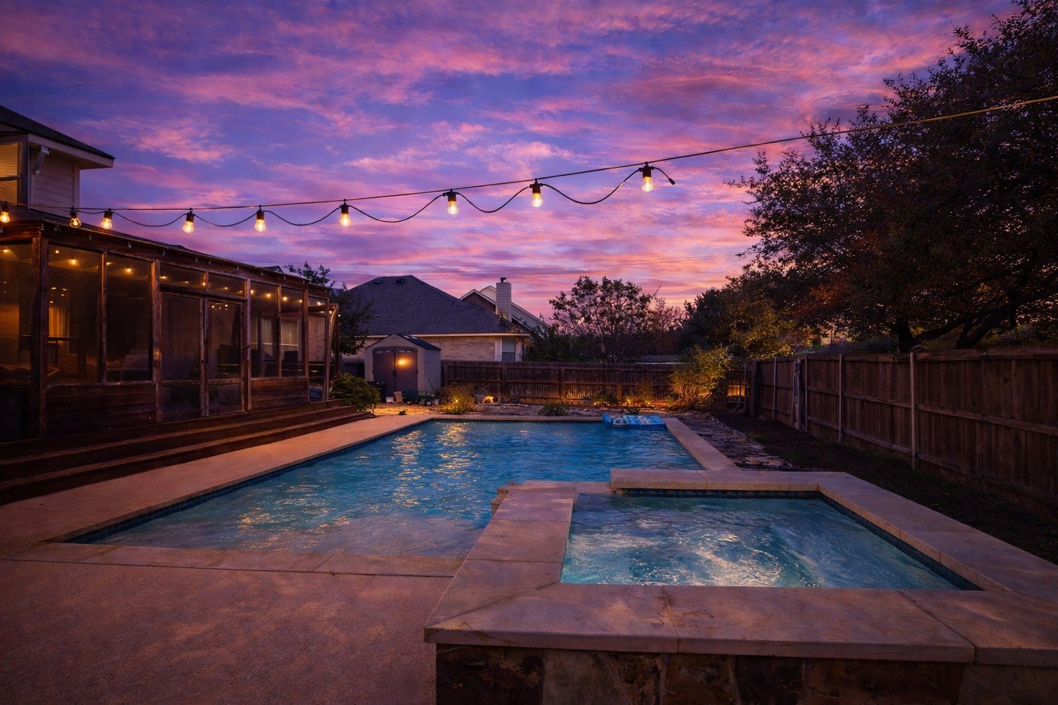 2603 White Stallion Way Leander, TX 78641 - Photo 2 of 40 Pool at dusk featuring a storage unit, a fenced backyard, a patio, a sunroom, and a pool with connected hot tub