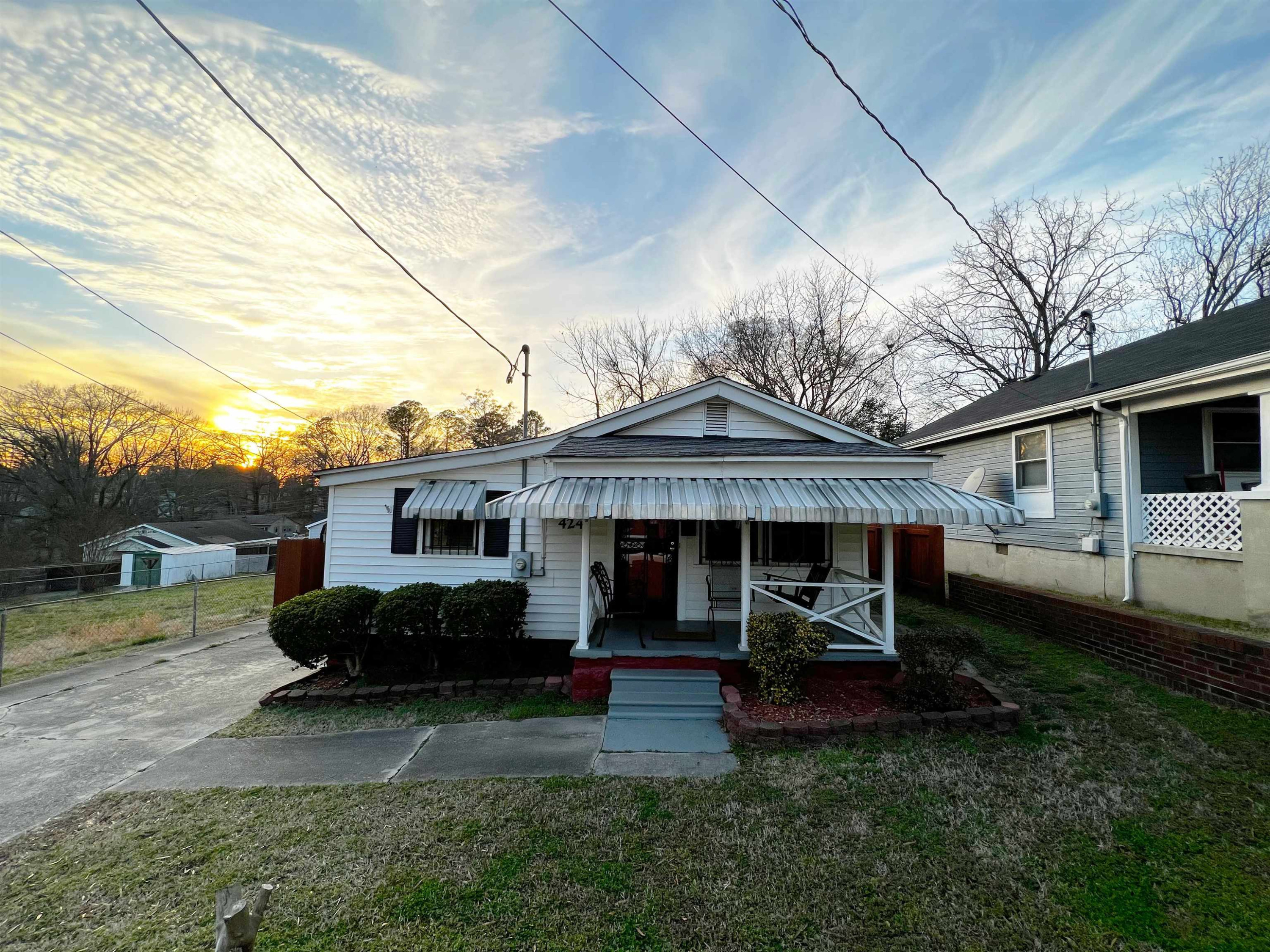 a front view of a house with a garden and trees