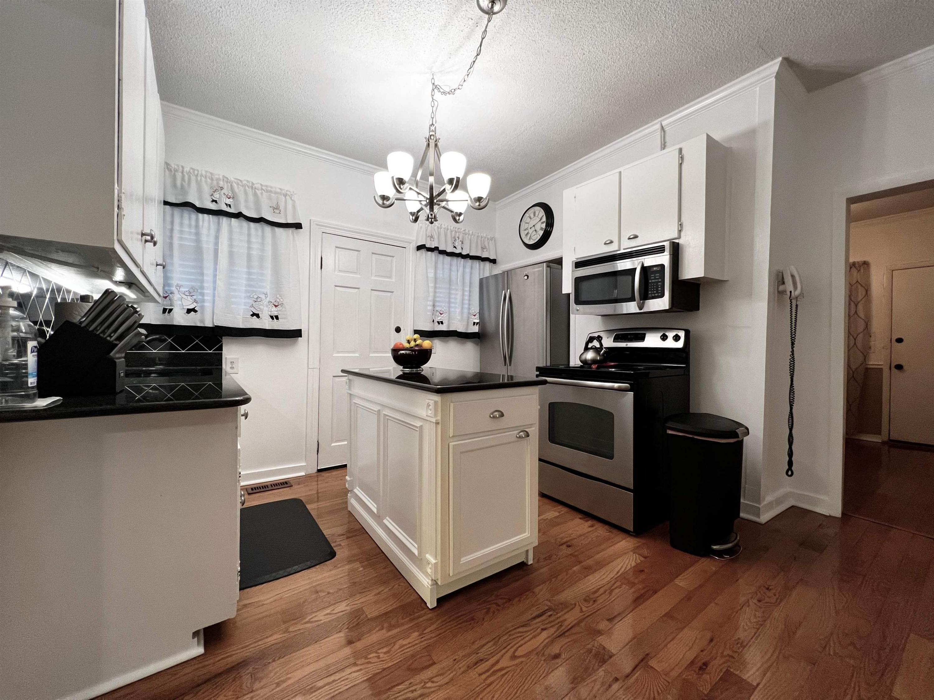 424 Eugene Street Durham, NC 27701 - Photo 9 of 26 a kitchen with stainless steel appliances granite countertop a refrigerator a stove a sink dishwasher and a dining table with wooden floor