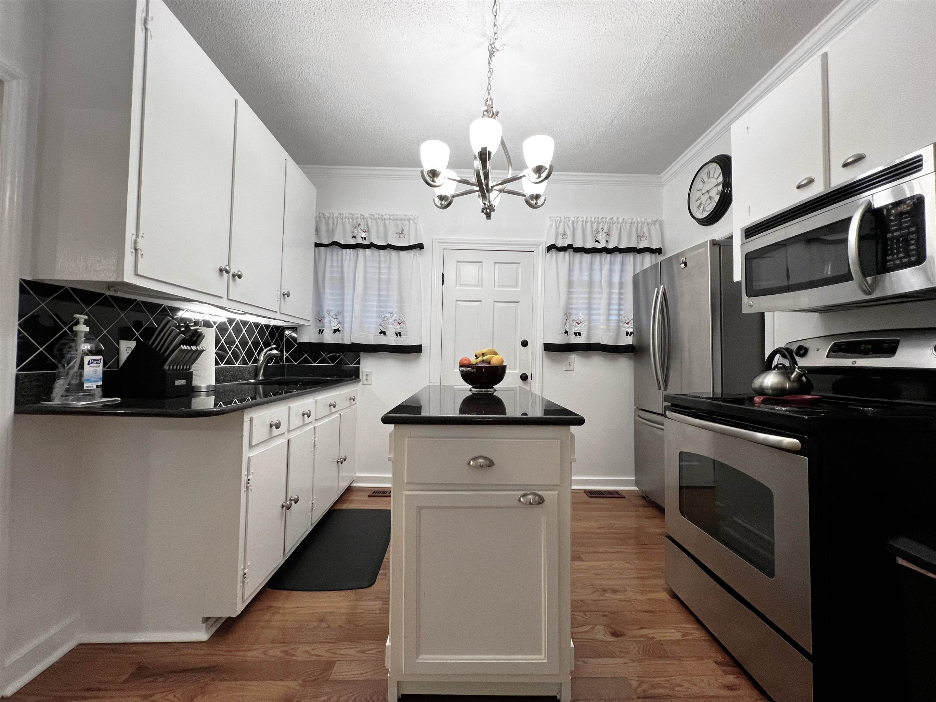 424 Eugene Street Durham, NC 27701 - Photo 10 of 26 a kitchen with stainless steel appliances granite countertop a stove and cabinets