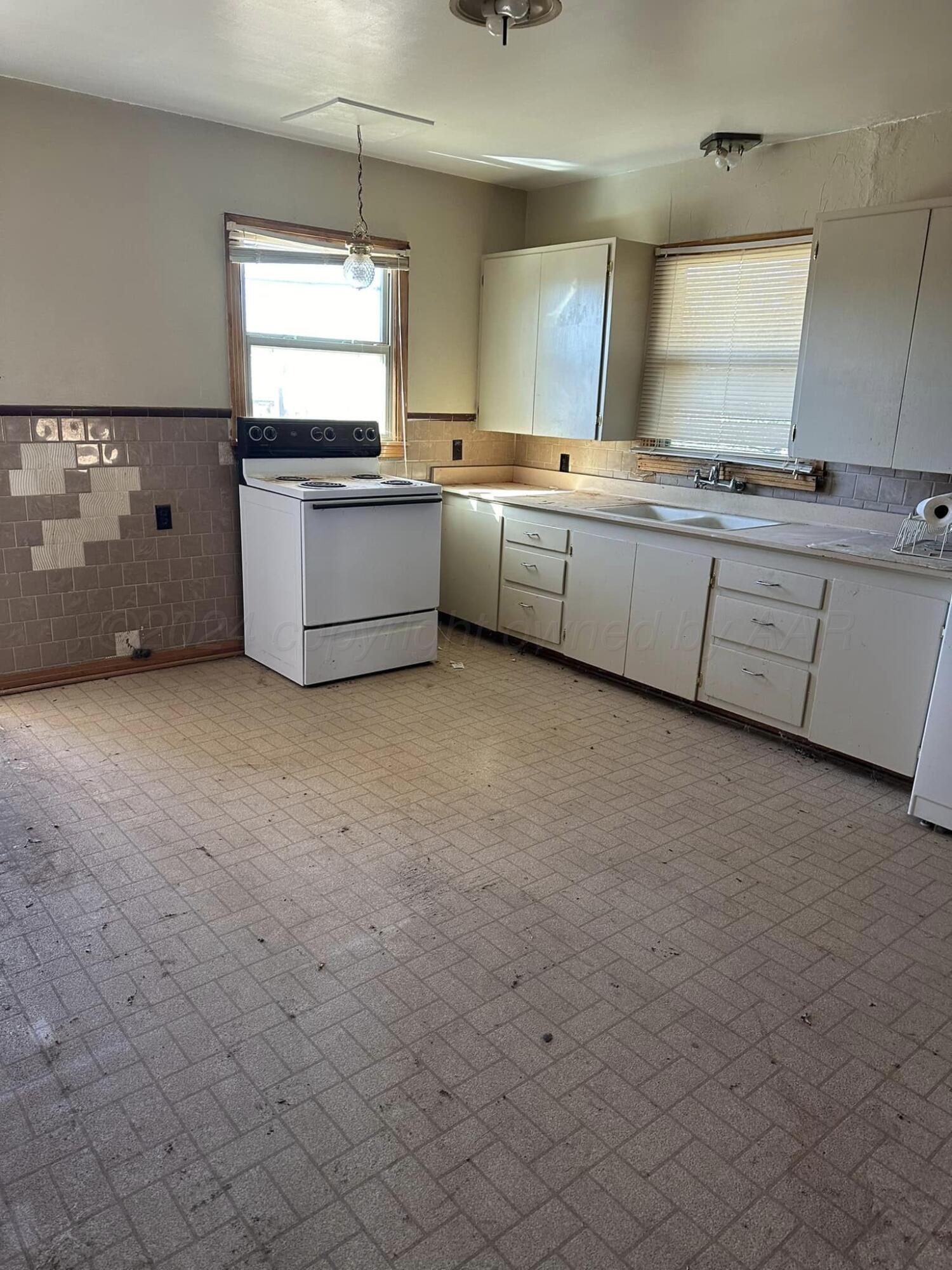 506 Ave O Sunray, TX 79086 - Photo 15 of 18 a kitchen with a sink window and cabinets