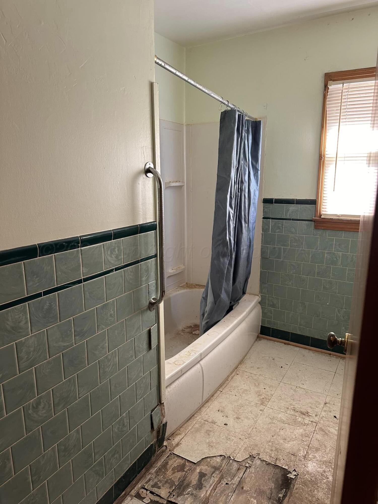 506 Ave O Sunray, TX 79086 - Photo 9 of 18 a bathroom with a bathtub and a shower