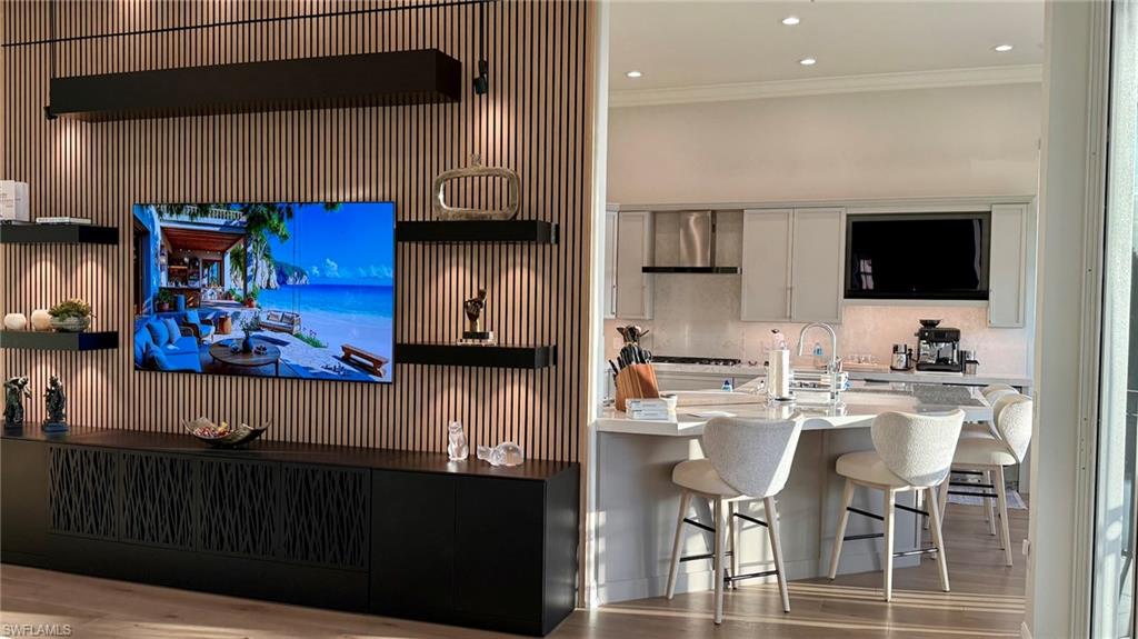 15536 Monterosso Lane, Unit 201 Naples, FL 34110 - Photo 6 of 29 a kitchen with stainless steel appliances kitchen island granite countertop a stove top oven a sink dishwasher and cabinets with wooden floor