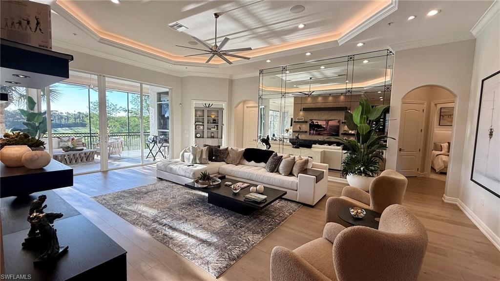 15536 Monterosso Lane, Unit 201 Naples, FL 34110 - Photo 9 of 29 a living room with furniture and a chandelier