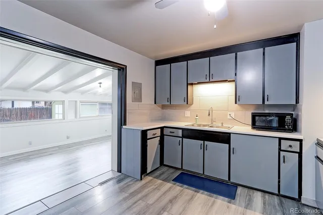 a kitchen with granite countertop white cabinets and wooden floor