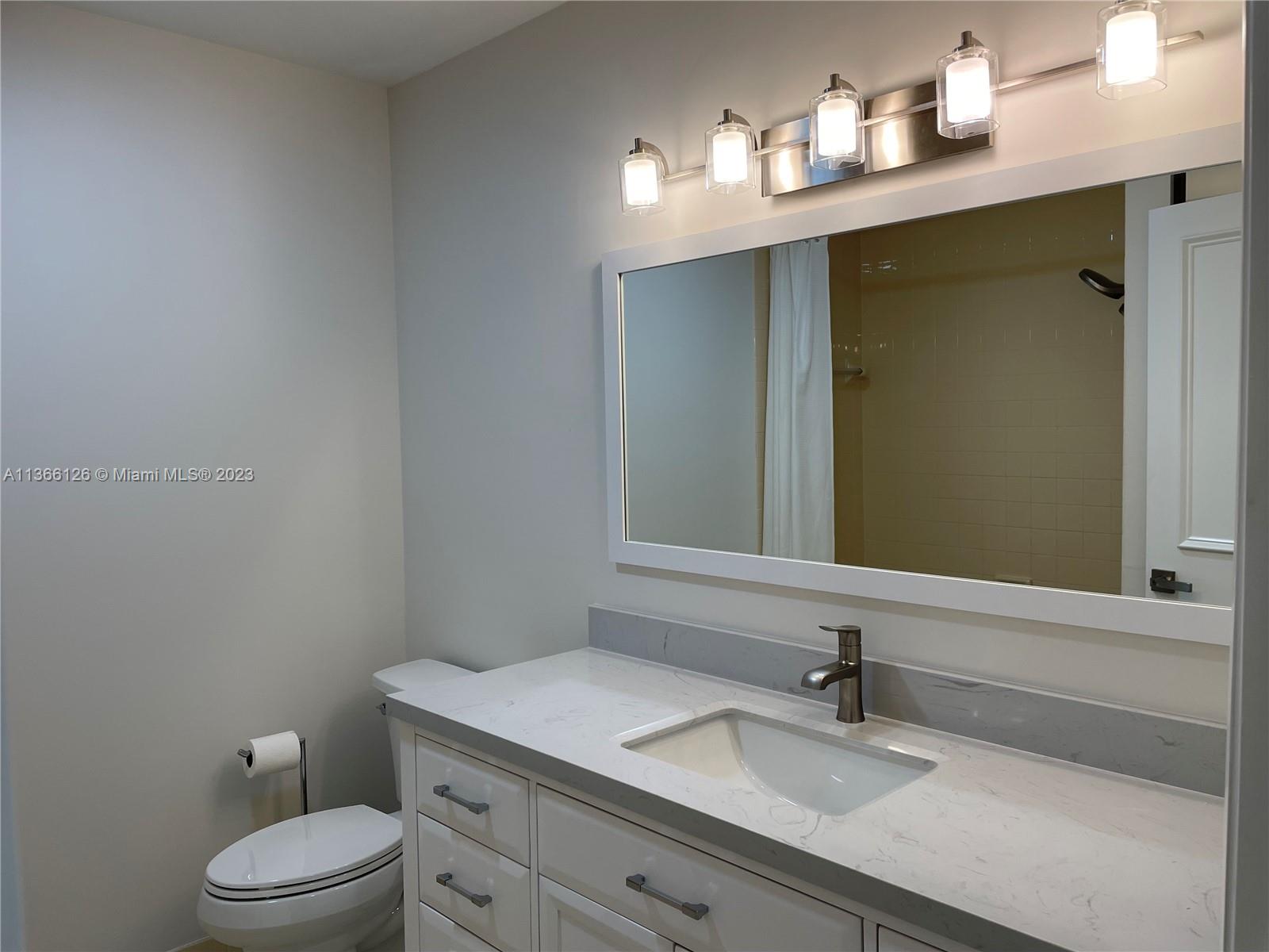 150 Harbourside Circle Jupiter, FL 33477 - Photo 32 of 61 a bathroom with a granite countertop sink a toilet and a mirror