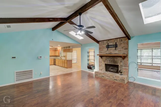 a view of an empty room with a fireplace and a window