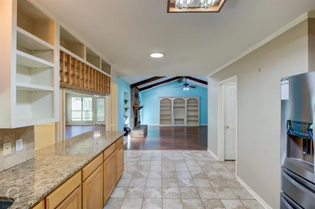 a bathroom with granite countertop a sink a toilet a window and a shower