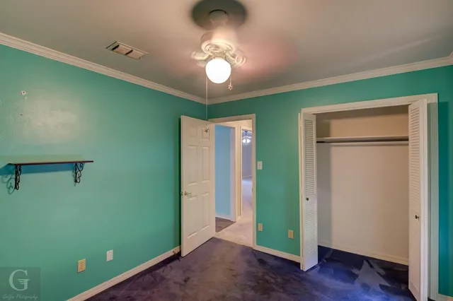 a view of a room with a fan and hardwood floor